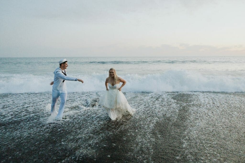 Bride and Groom sharing a lighthearted moment in the ocean on their wedding day